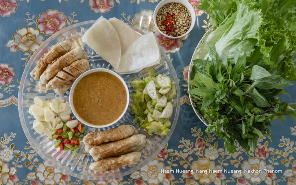 Plateau de Naem Nueang servi à Nakhon Phanom, composé de viande grillée, galettes de riz, légumes frais, herbes aromatiques, ail, piments et sauces d'accompagnement.