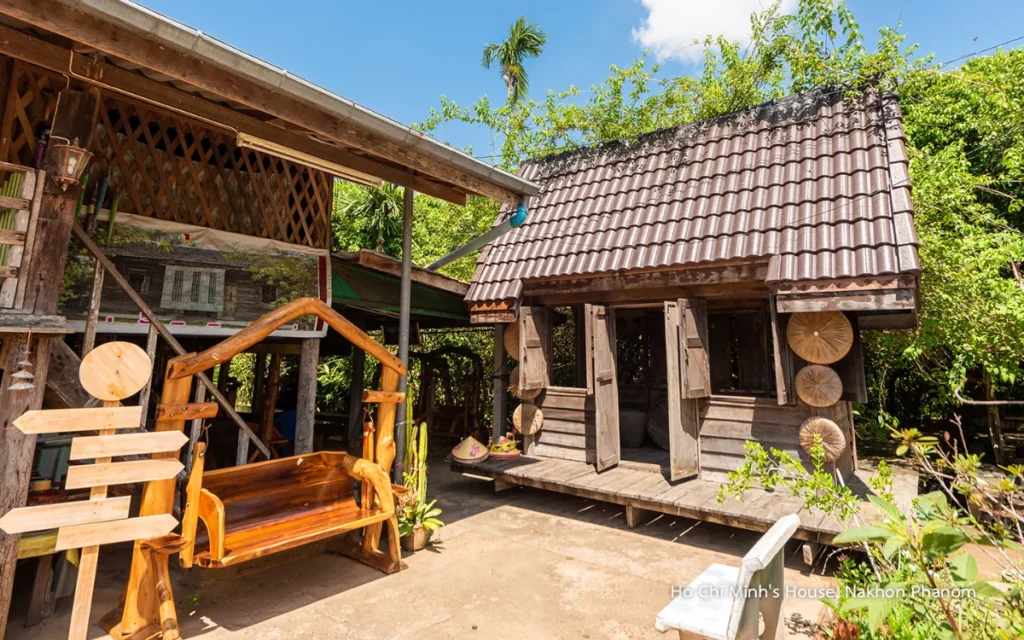 Buitenaanzicht van een traditioneel houten huis op de historische locatie van Ho Chi Minh in Ban Na Chok, Nakhon Phanom, omgeven door groen en handgemaakt houten meubilair.