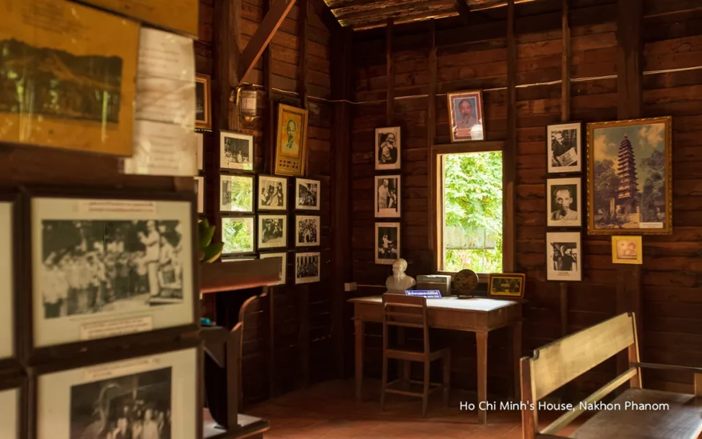 Intérieur de la maison historique de Hô Chi Minh à Nakhon Phanom, présentant des murs en bois, des photographies anciennes, des portraits et du mobilier traditionnel.