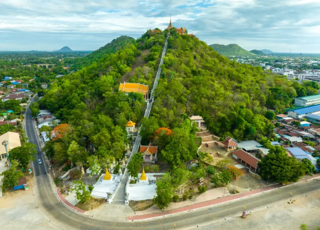 Breed luchtpanorama van de groene Khao Sakae Krang-heuvel, met de gouden tempel en de stad.